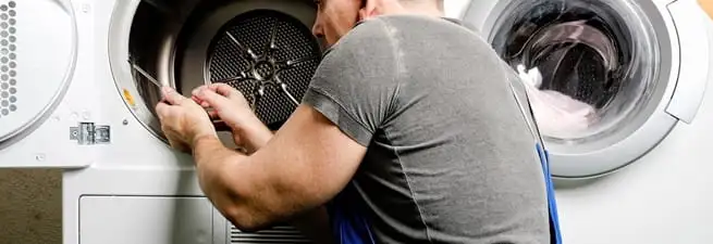 Dryer repair technician fixing a clothes dryer drum in Spokane, WA
