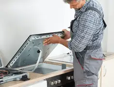 Appliance repair technician installing a built-in cooktop in Spokane, WA