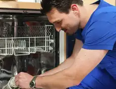 Dishwasher repair technician inspecting and servicing an open dishwasher in Spokane, WA