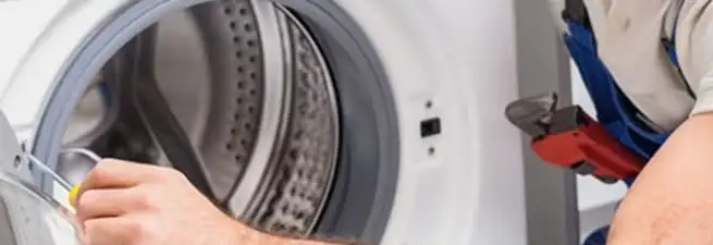 Appliance technician repairing a clothes dryer drum and internal parts in Spokane, WA
