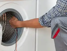 Dryer repair technician diagnosing and servicing a clothes dryer in Spokane, WA
