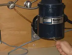 Garbage disposal repair technician tightening the mounting ring under a sink in Spokane, WA