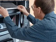 Appliance repair technician replacing a microwave vent filter in Spokane, WA