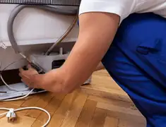 Appliance repair technician fixing refrigerator water line and connections in Spokane, WA