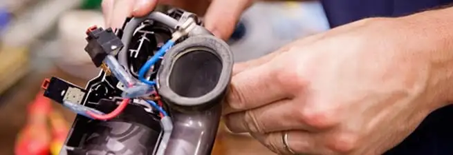 Vacuum repair technician reconnecting wiring and components in Spokane, WA