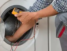Washing machine repair technician testing a front-load washer with diagnostic tools in Spokane, WA