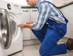 Washing machine repair technician servicing a front-load washer in Spokane, WA