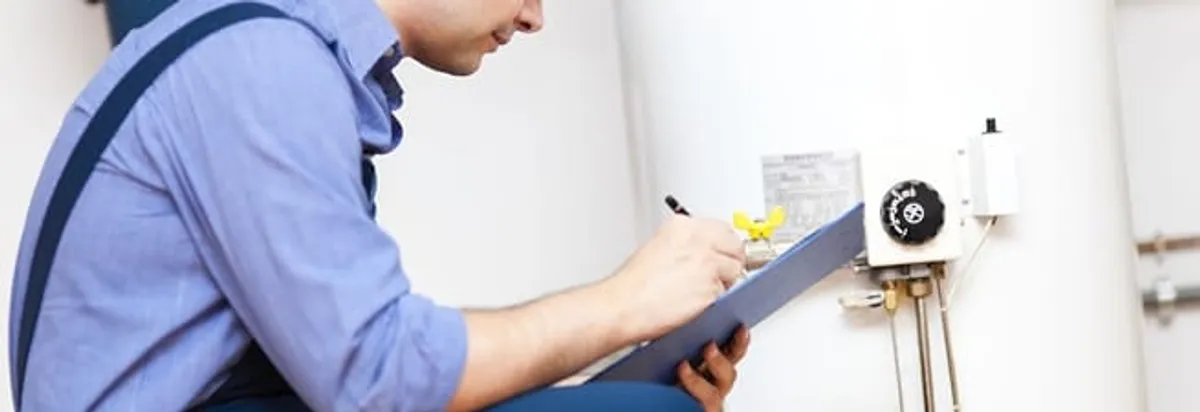 Water heater repair technician inspecting the unit and recording service notes in Spokane, WA