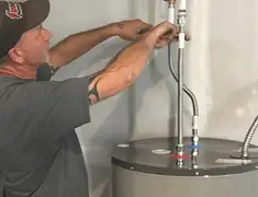 Water heater repair technician tightening supply line connections in Spokane, WA